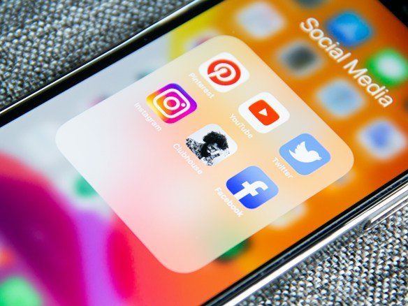 A phone being used to share and adapt content across two different social media platforms